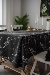 Detail of black marble print tablecloth made of cotton linen fabric on a dining table