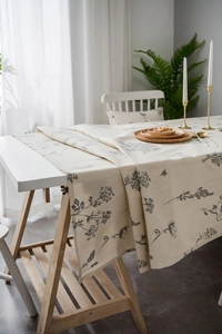Detail of linen tablecloth featuring elegant bee and botanical sketch patterns