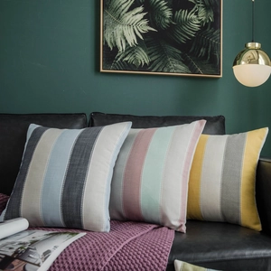 Set of modern minimalist striped decorative throw pillows on a black leather sofa