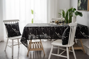 Detail view of black marble print tablecloth and matching square cushion in modern setting