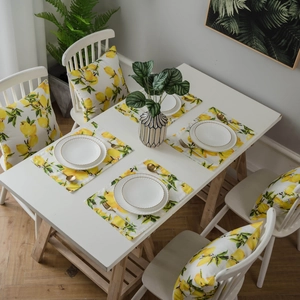 Lemon print placemat and cushion set with vibrant yellow citrus fruits and green leaves