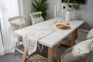 Close-up of floral table runner and matching cushion with elegant botanical sketches