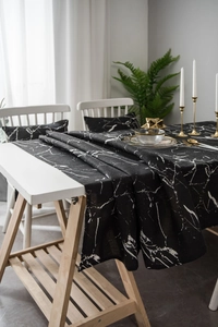 Detailed view of black marble print tablecloth and matching cushion in a home setting