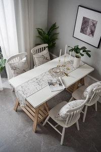 Detail of modern marble pattern table runner and matching pillows on a dining table