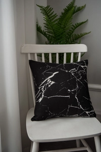 Macro view of square throw pillow with marble pattern on a wooden Nordic chair