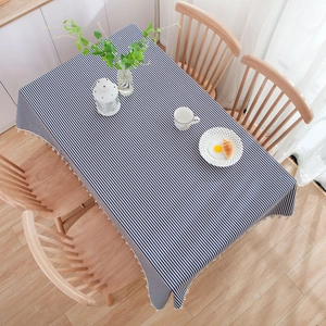 Close-up of navy blue and white striped tablecloth with elegant white fringe tassel detail