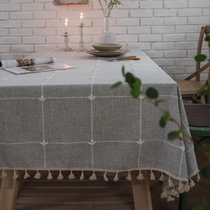 Grey checkered tablecloth with fringe tassels and delicate floral embroidery details