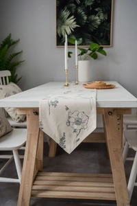 Detailed texture of cotton linen table runner with gray floral and bee prints