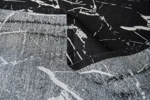 Detail view of marble print tablecloth showing fine weaving texture and hemmed edge finish