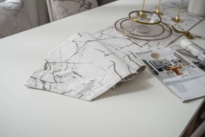 Detail of modern white table runner featuring a grey marble pattern and fabric texture