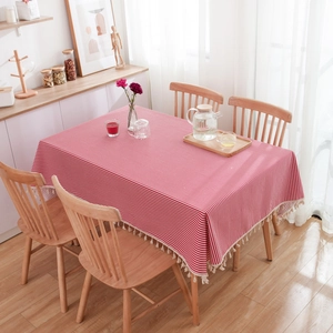 Close-up of red and white striped tablecloth with elegant tassel fringe in natural light