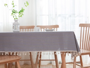 Close-up of blue and white striped Nordic tablecloth with elegant white tassel fringe