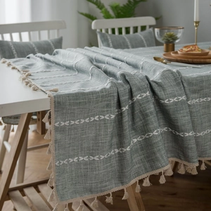 Linen tablecloth with gray-green geometric embroidery and white fringe tassels