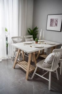 Detail of modern minimalist table runner on a white dining table with Nordic wood chairs