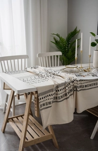 Detailed texture of bohemian linen tablecloth with geometric patterns and natural tassels