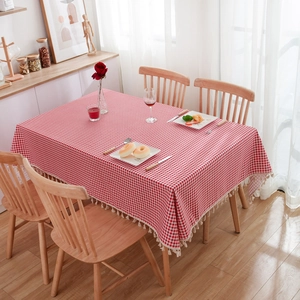 Detail of red checkered tablecloth with cotton linen texture and decorative white tassels