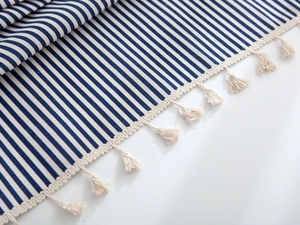 Close-up of navy blue and white striped fabric texture with delicate tassel edge detail