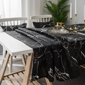 Modern black marble print tablecloth and matching pillows in a minimalist home setting