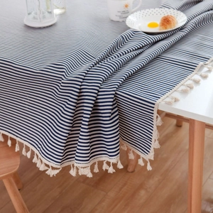 Nordic navy blue striped tablecloth with cream tassels on a modern dining table