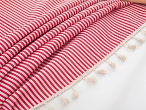Close-up of red and white striped fabric with soft fringe tassels and woven texture