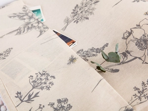 Close-up of linen dust cover featuring bee and floral prints with a storage pocket
