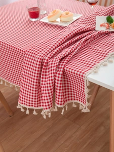 Close-up of red and white plaid cotton linen tablecloth with delicate beige fringe edges