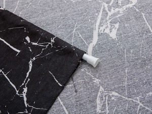 Detail of rod pocket header on black marble print modern door curtain fabric