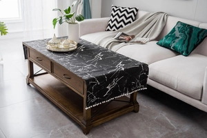 Detail of black marble pattern table runner with decorative white pompom fringe trim