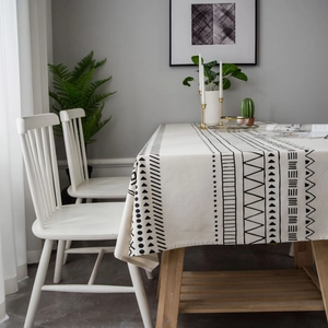 Bohemian style cream linen tablecloth with black geometric patterns on a wooden table