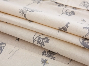 Detailed macro view of cream linen fabric with grey floral print and bee motif