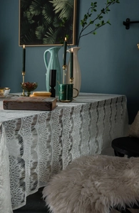 Macro shot of intricate hollow lace detail and scalloped edges on white tablecloth