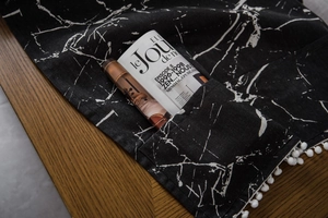 Detail of marble pattern cotton linen table cloth with pompom fringe and storage pocket