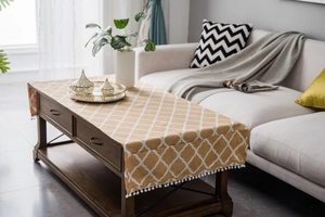 Detail of mustard yellow linen table runner with white geometric diamonds and pom-pom trim