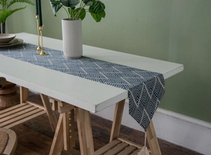 Close-up of blue and white geometric herringbone weave and fringe tassels on table runner