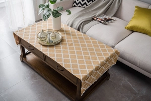 Close-up of yellow geometric cotton linen tablecloth with white pom-pom trim detail