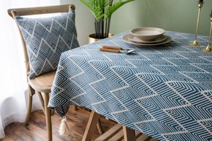 Close-up of navy blue geometric jacquard tablecloth with elegant white fringe details