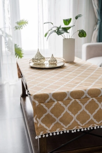 Detail of cotton linen table runner featuring pom-pom fringe and side storage pocket