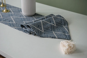 Close-up of Nordic navy blue jacquard table runner featuring geometric weaving and tassels