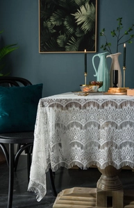 Detail of white eyelash lace tablecloth with complex floral hollow embroidery and scalloped edges