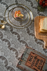 Detail of white hollow lace tablecloth with intricate floral patterns for rustic decor