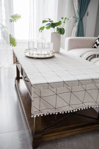 Detail of modern cotton linen table runner with geometric triangles and white pom-poms