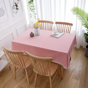 Pink cotton linen tablecloth with white hearts and lace trim on wooden table