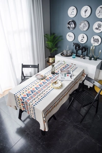 Detail of bohemian geometric tablecloth in cream on a dining table with ethnic patterns