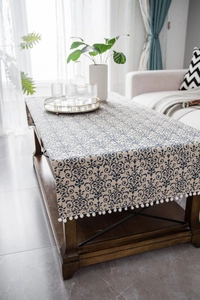 Close-up of vintage damask pattern table runner with white pom-pom fringe details