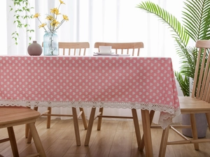 Detail of pink cotton linen tablecloth with white hearts and delicate lace edge trim