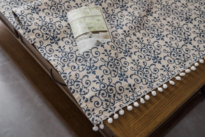 Detail view of cotton linen table cover featuring blue floral patterns and side pockets