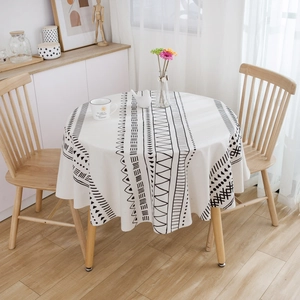 Detail of bohemian round tablecloth with black geometric patterns on beige linen fabric