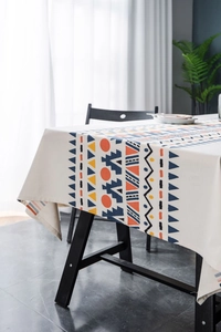 Detail of bohemian geometric print tablecloth with tassels on a home dining table