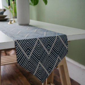 Nordic geometric blue and white table runner with tassels on a modern dining table