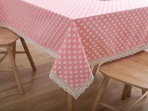 Detailed view of pink floral tablecloth with white heart pattern and elegant lace edge